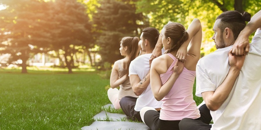 4 jonge mensen doen aan yoga in een park 4 jonge mensen doen aan yoga in een park
